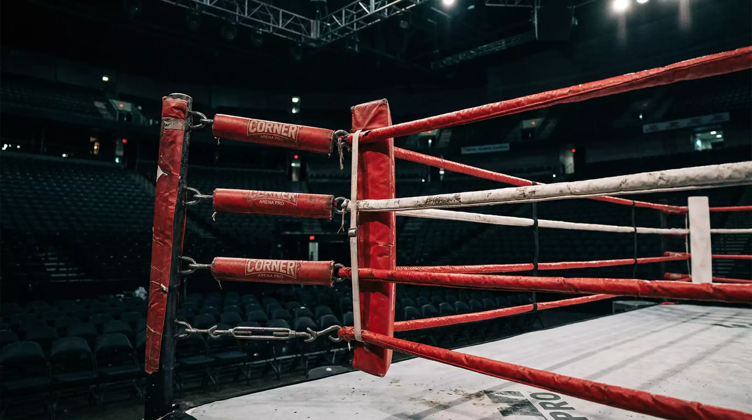 Coin d'un ring de boxe avec le panneau des rounds visible en arrière-plan